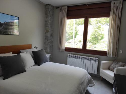 a bedroom with a white bed and a window at Incles Principat in Canillo