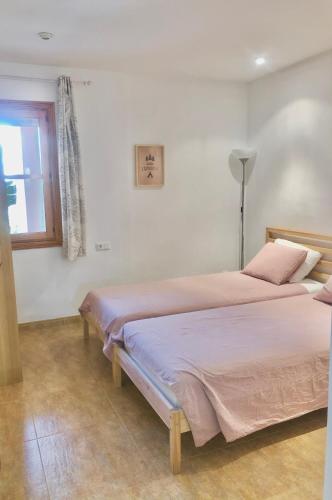 two beds in a white room with a window at Balco d’es Trenc in Sa Ràpita
