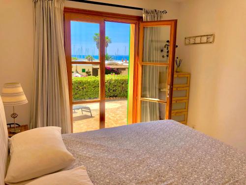 a bedroom with a bed and a sliding glass door at Balco d’es Trenc in Sa Ràpita