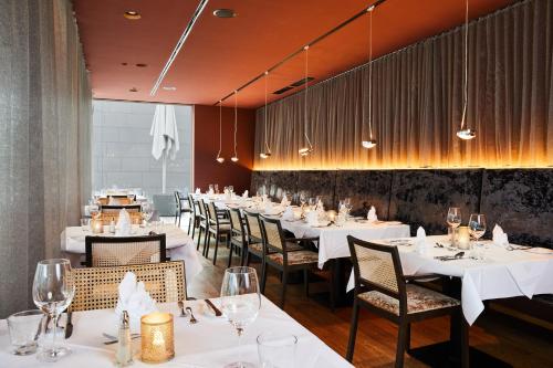 a dining room with white tables and chairs at Luxury All Inclusive Resort Schwarzbrunn 4 Sterne Superior in Stans