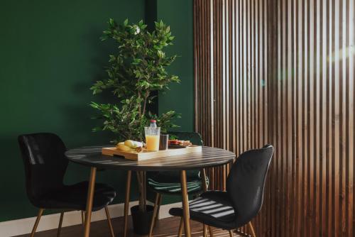 a table with black chairs and a green wall at K-Houses B2 in Arta