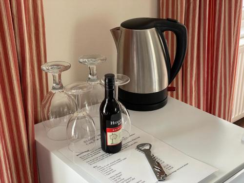 a bottle of wine and two glasses on a counter at Station House, Dartmoor and Coast located, Village centre Hotel in South Brent
