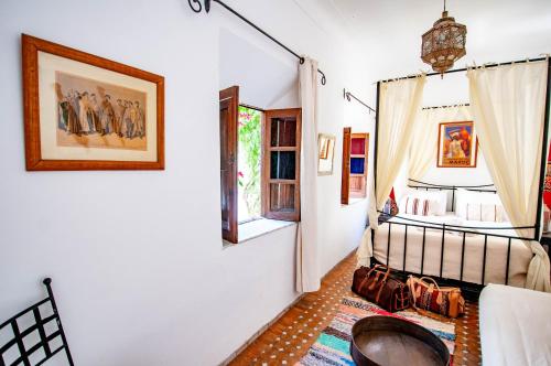 a living room with a bed and a window at Hotel & Spa Riad Dar El Aila in Marrakech