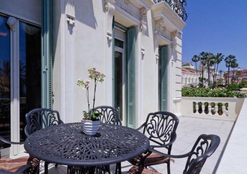 a black table and chairs on a patio at Hotel De Paris Sanremo in Sanremo