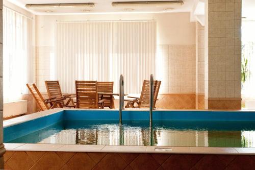 a pool of water with chairs and a table at Cranz Hotel in Zelenogradsk
