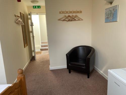 a black chair sitting in the corner of a room at Station House, Dartmoor and Coast located, Village centre Hotel in South Brent
