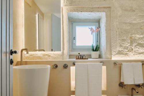 a bathroom with a sink and a mirror and towels at 1783 Dimora d'Epoca in Locorotondo