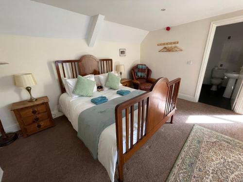 a bedroom with a large bed and a chair at Station House, Dartmoor and Coast located, Village centre Hotel in South Brent