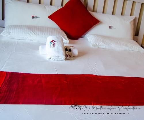 a bed with two towels and a teddy bear on it at Smart Diva Accommodation in East London