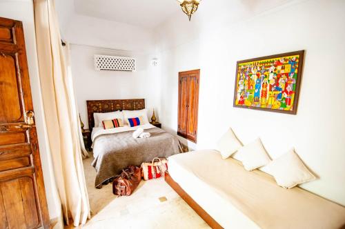 a bedroom with two beds and a door to a room at Hotel & Spa Riad Dar El Aila in Marrakech