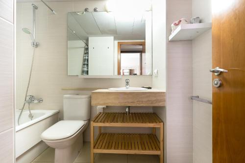 une salle de bains avec toilettes, lavabo et miroir dans l'établissement the beach milenium, à Roses
