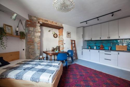 Cet appartement comprend une chambre avec un lit et une table ainsi qu'une cuisine. dans l'établissement Apartament przy Katedrze, à Lublin