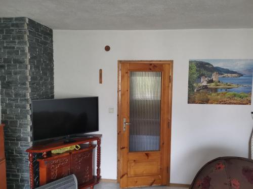 a room with a television and a door at Къща Томови,стаи за гости in Devin