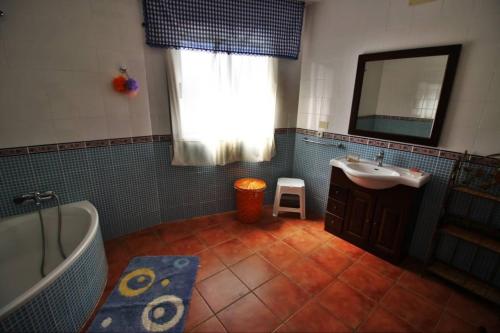 a bathroom with a tub and a sink and a mirror at Casa de Padrón in Padrón
