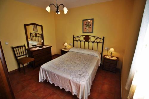 a bedroom with a bed and a dresser and a mirror at Casa de Padrón in Padrón