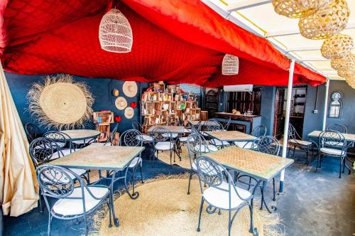 a restaurant with tables and chairs under a red tent at Hotel & Spa Riad Dar El Aila in Marrakech