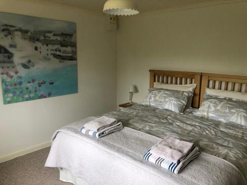 a bedroom with a bed with two towels on it at Sycamore Bungalow in Perranwell