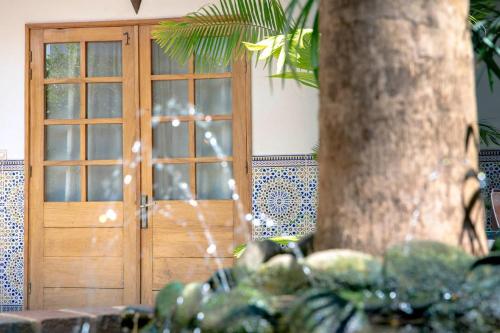 a wooden door in a room with a tree at Casa Mara Dakar in Dakar