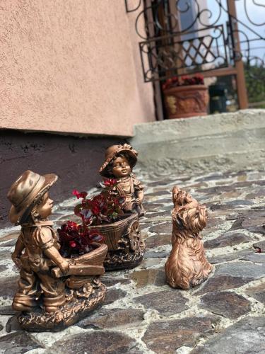 three statues of children and a dog on a patio at Шервуд in Myta