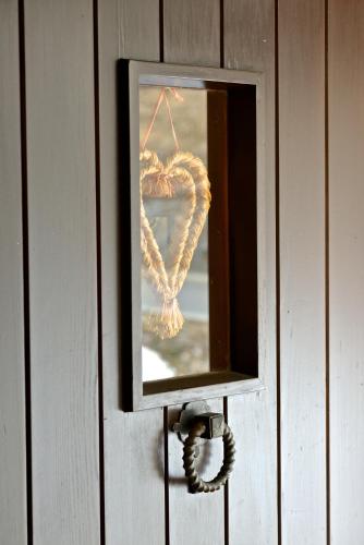 a mirror with a heart hanging on a wall at Chesa Panorama in Celerina