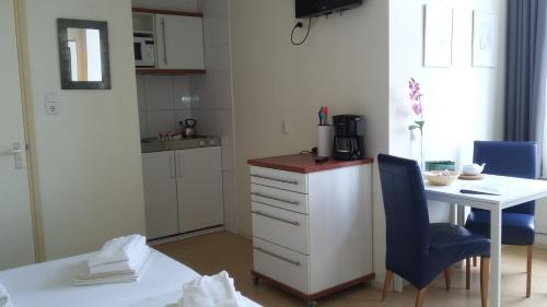 a kitchen with a desk and a table and a blue chair at Hotel Rasch in Bergen aan Zee