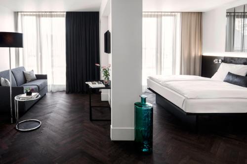 a bedroom with a bed and a living room at Hotel AMANO Grand Central in Berlin