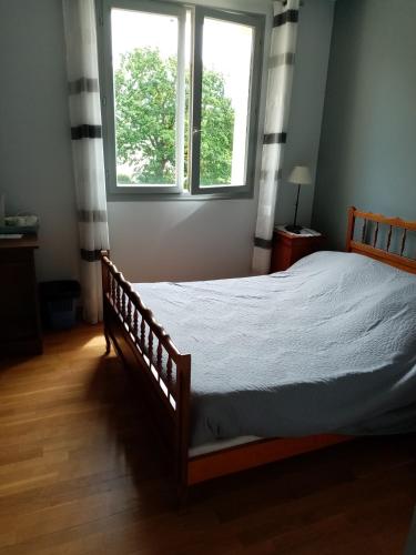 a bedroom with a bed and two windows at la Bergerie in Tréméreuc