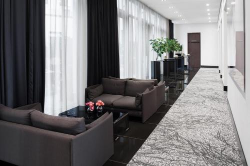 a living room with couches and a table at Hotel AMANO Grand Central in Berlin