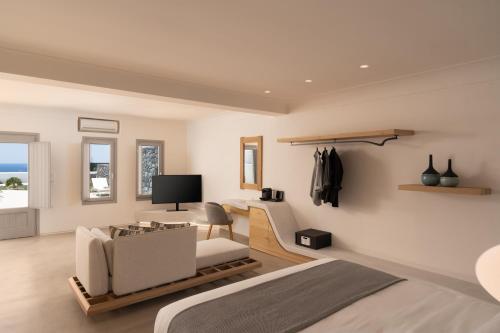 a bedroom with a bed and a couch and a desk at La Ponta Villas & Suites in Akrotiri