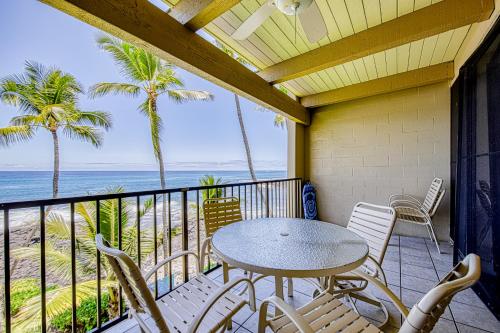 a balcony with a table and chairs and the ocean at Kona Bali Kai #321 in Kailua-Kona