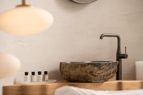 a bathroom sink with a copper bowl and a faucet at La Ponta Villas & Suites in Akrotiri
