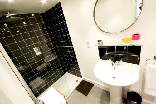 a bathroom with a toilet and a sink and a mirror at Dog and Whistle Pub in Hertford