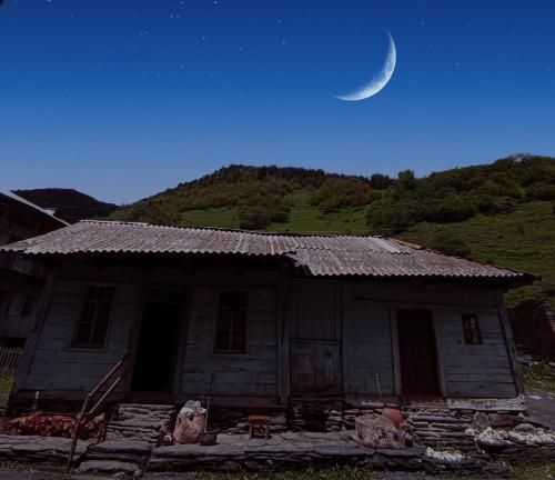 an old house with the moon in the sky at Raul Lushnu Darbaz in Mestia
