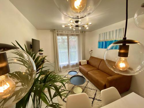 una sala de estar con un sofá y una mesa en La Fleur Marine Classé 3 étoiles - Accès direct mer Cabourg, en Cabourg