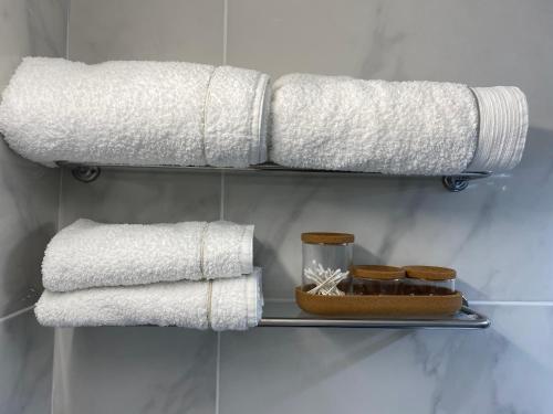 un toallero con toallas blancas y un plato de galletas en La Fleur Marine Classé 3 étoiles - Accès direct mer Cabourg, en Cabourg