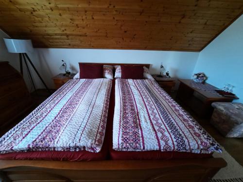 a large bed in a room with a wooden ceiling at Anna vendégház in Tihany
