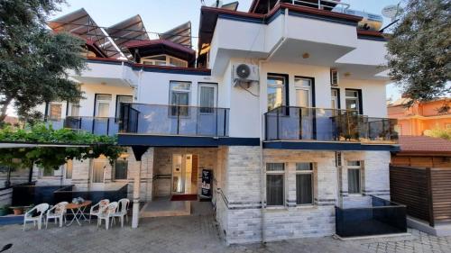 a house with balconies and a table and chairs at Mut Apart Hotel in Fethiye