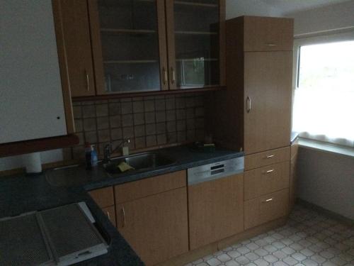 a kitchen with wooden cabinets and a sink at Ponnies Haus in Surwold