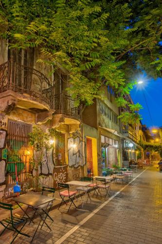 an empty street at night with tables and chairs at Ivis 4 Boutique Hotel in Athens
