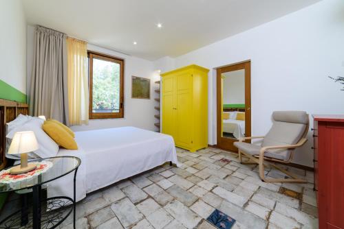 a bedroom with a bed and a chair and a table at B&B Albachiara Casa di Campagna in Ogliastro Cilento