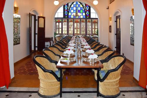 a long dining room with a long table and chairs at The House of MG-A Heritage Hotel, Ahmedabad in Ahmedabad