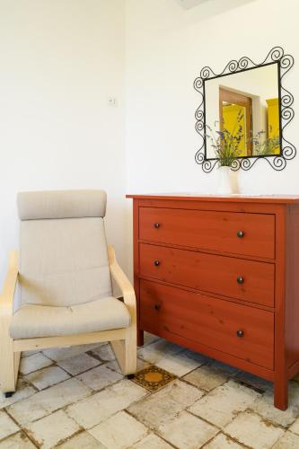 a bedroom with a dresser and a chair and a mirror at B&B Albachiara Casa di Campagna in Ogliastro Cilento