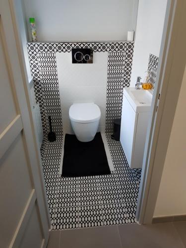 a bathroom with a toilet and a black and white tile floor at Joli appartement avec vue sur la Loire in Amboise