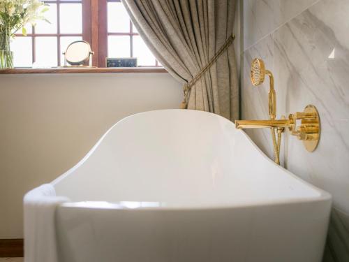 a white sink in a bathroom with a window at The Homestead at Hazendal, in Stellenbosch Winelands by NEWMARK in Stellenbosch
