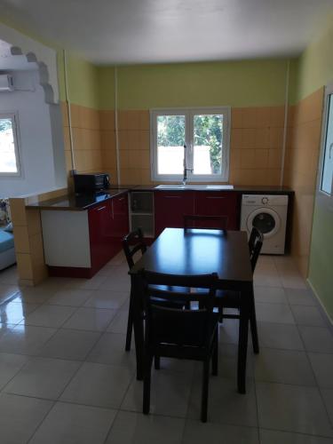 a kitchen with a table and chairs in a room at Ciel du sud in Mbouini