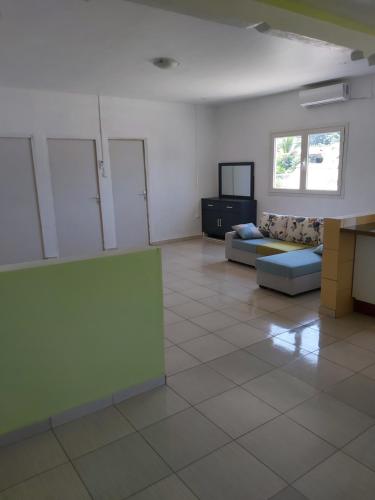 een woonkamer met een bank en een tv bij Ciel du sud in Mbouini