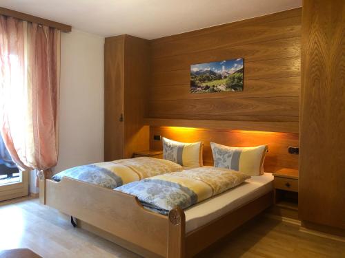 um quarto com uma cama grande e paredes de madeira em Gästehaus am Kurparkweg em Reit im Winkl