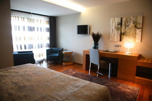 a hotel room with a desk and a bed and a desk and chair at Hotel Ego in Viveiro