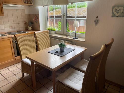a kitchen with a wooden table and chairs and a table and a window at Röhrshof in Bispingen