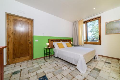 um quarto com uma cama grande e uma janela em B&B Albachiara Casa di Campagna em Ogliastro Cilento
